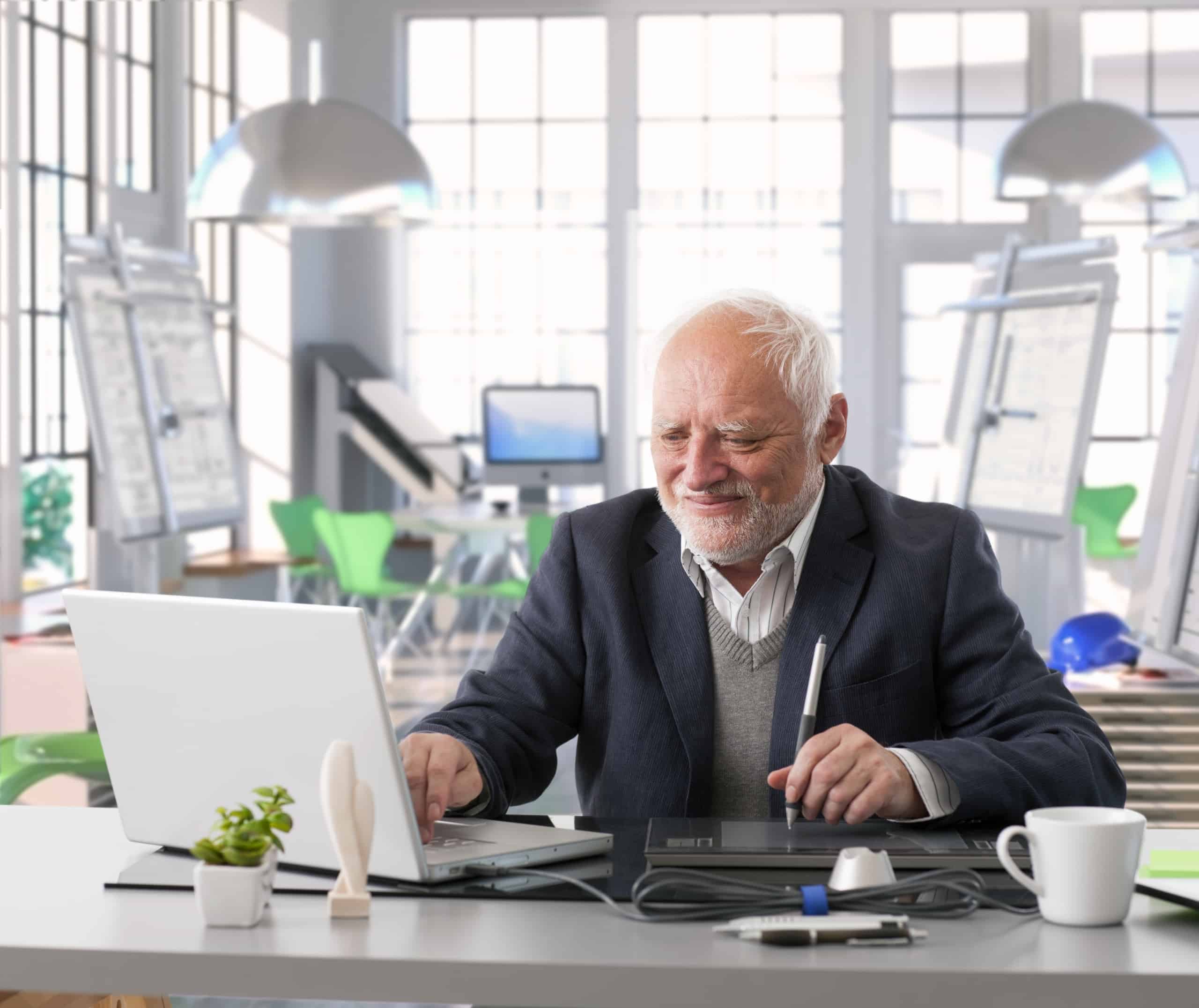 Senior employee working on laptop in office