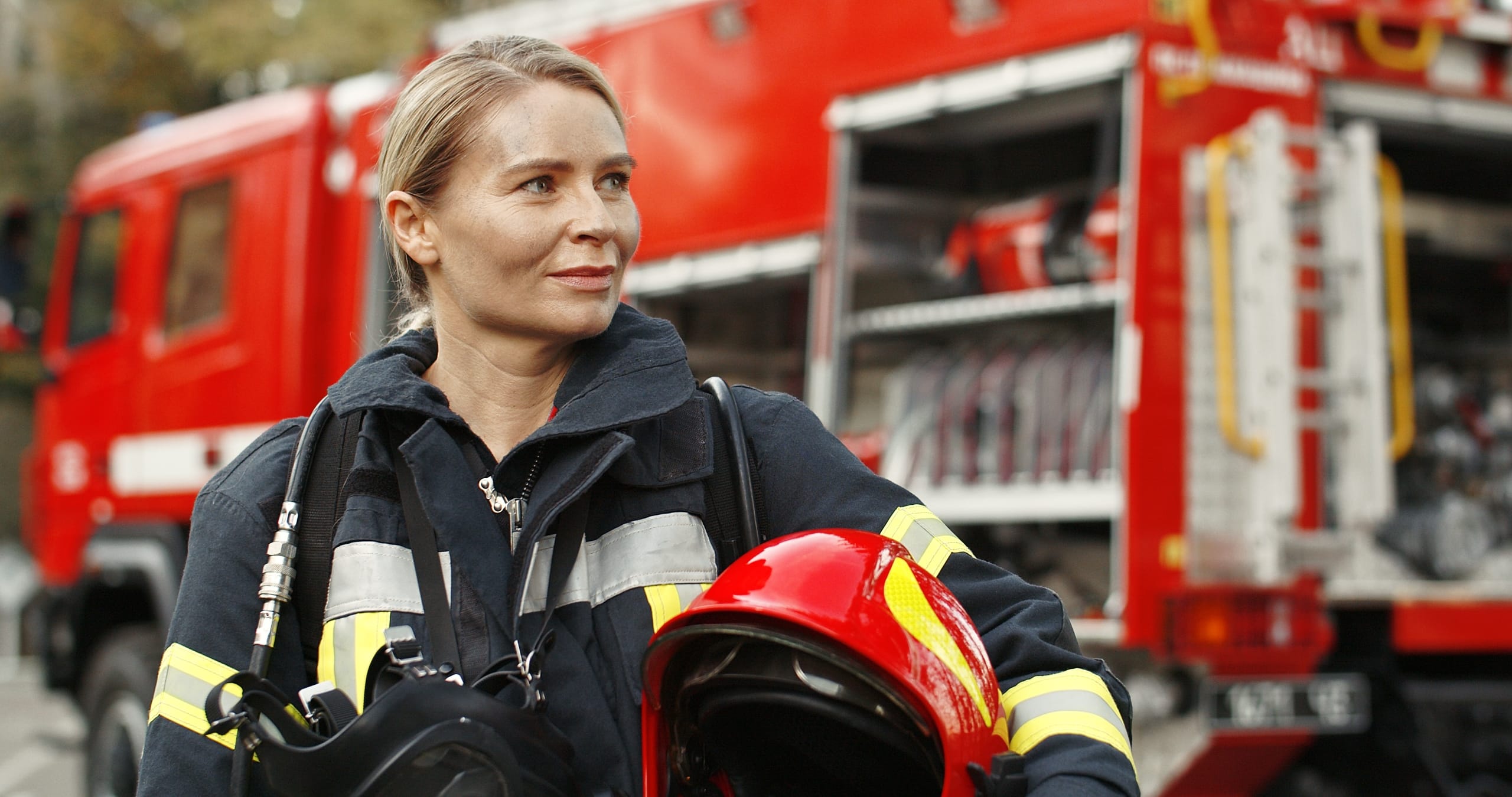 woman firefighter standing near fire truck.