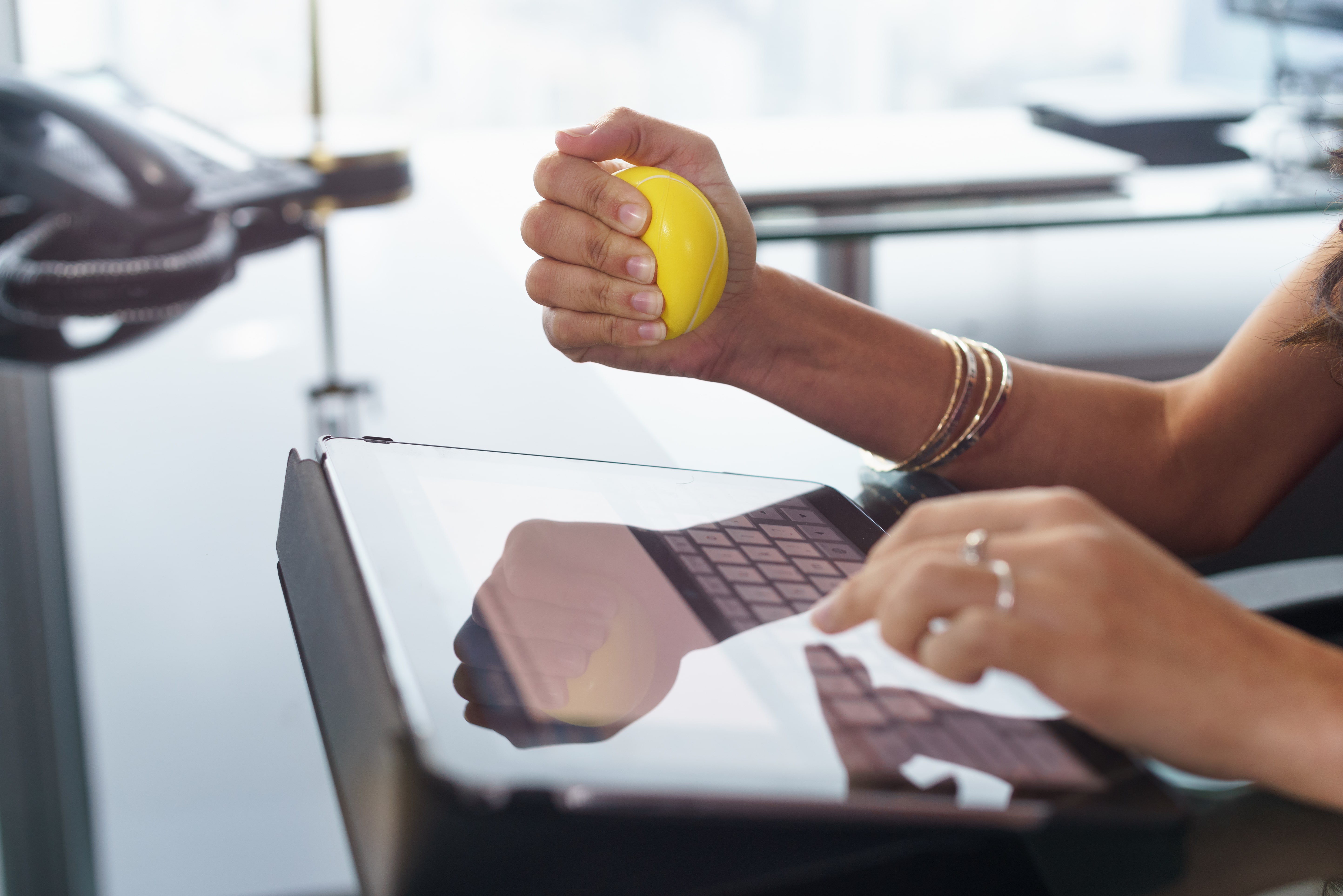 hand squeezing stress ball in office