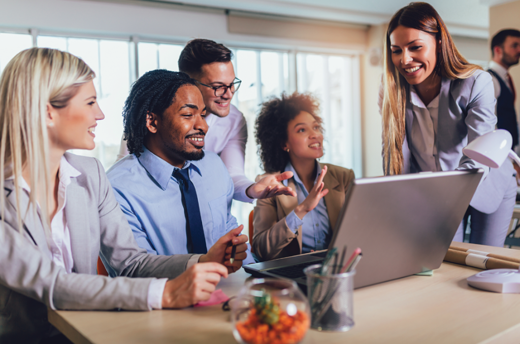 Multiracial employees working happily together on a laptop