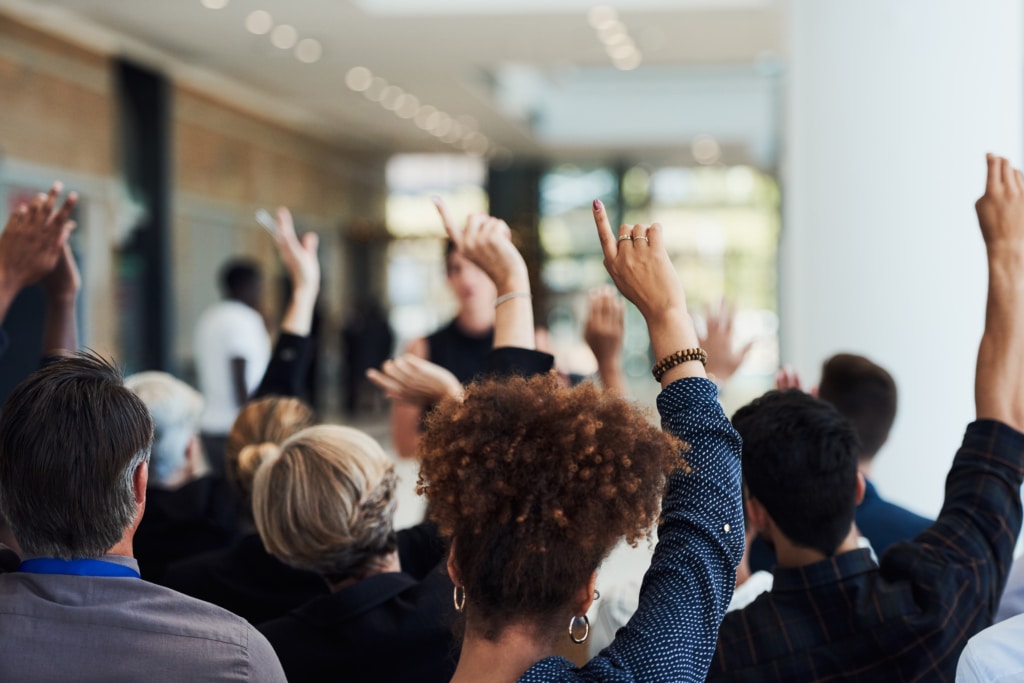 room of people with hands raised