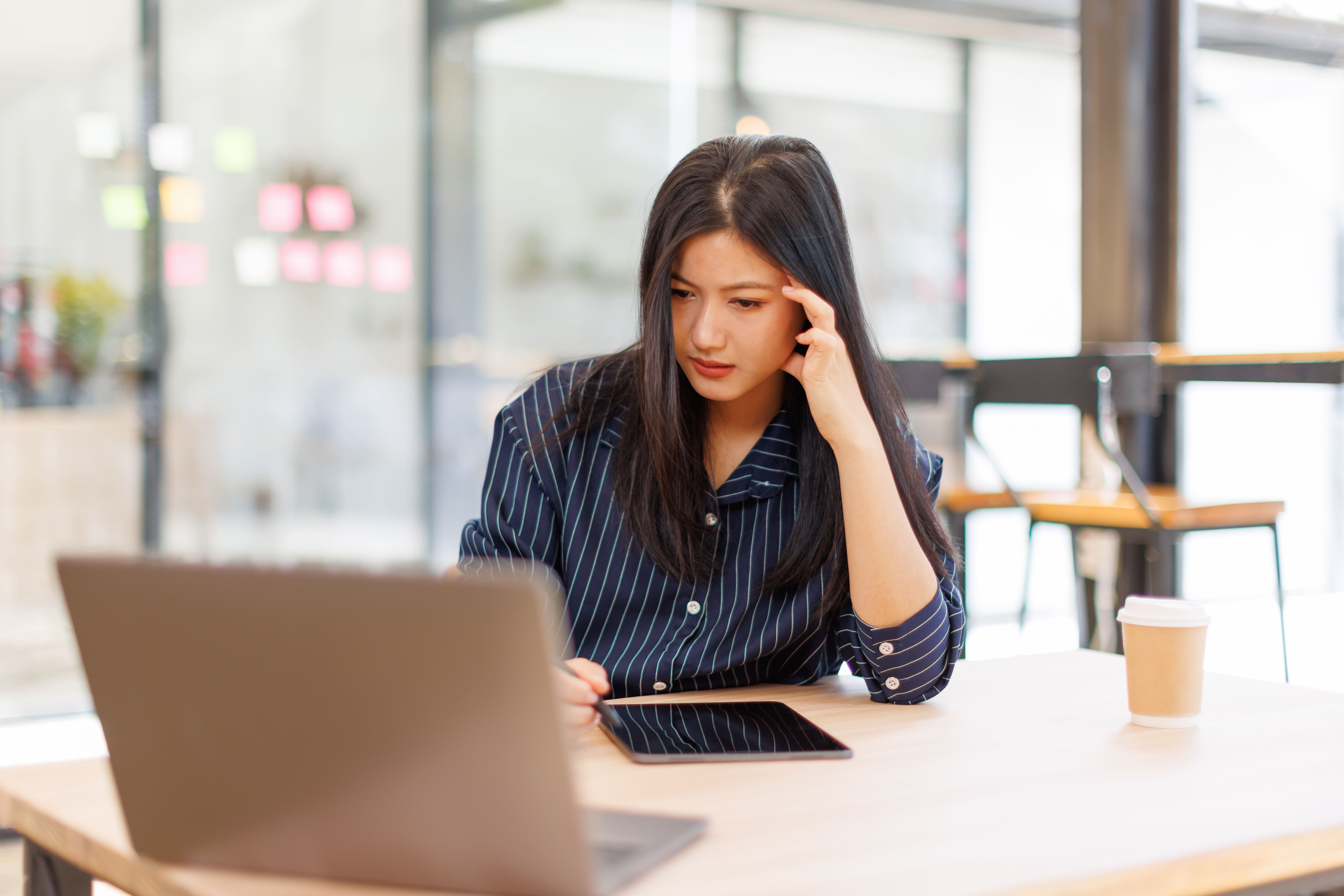 uncertainty in the workplace woman exhausted working on laptop