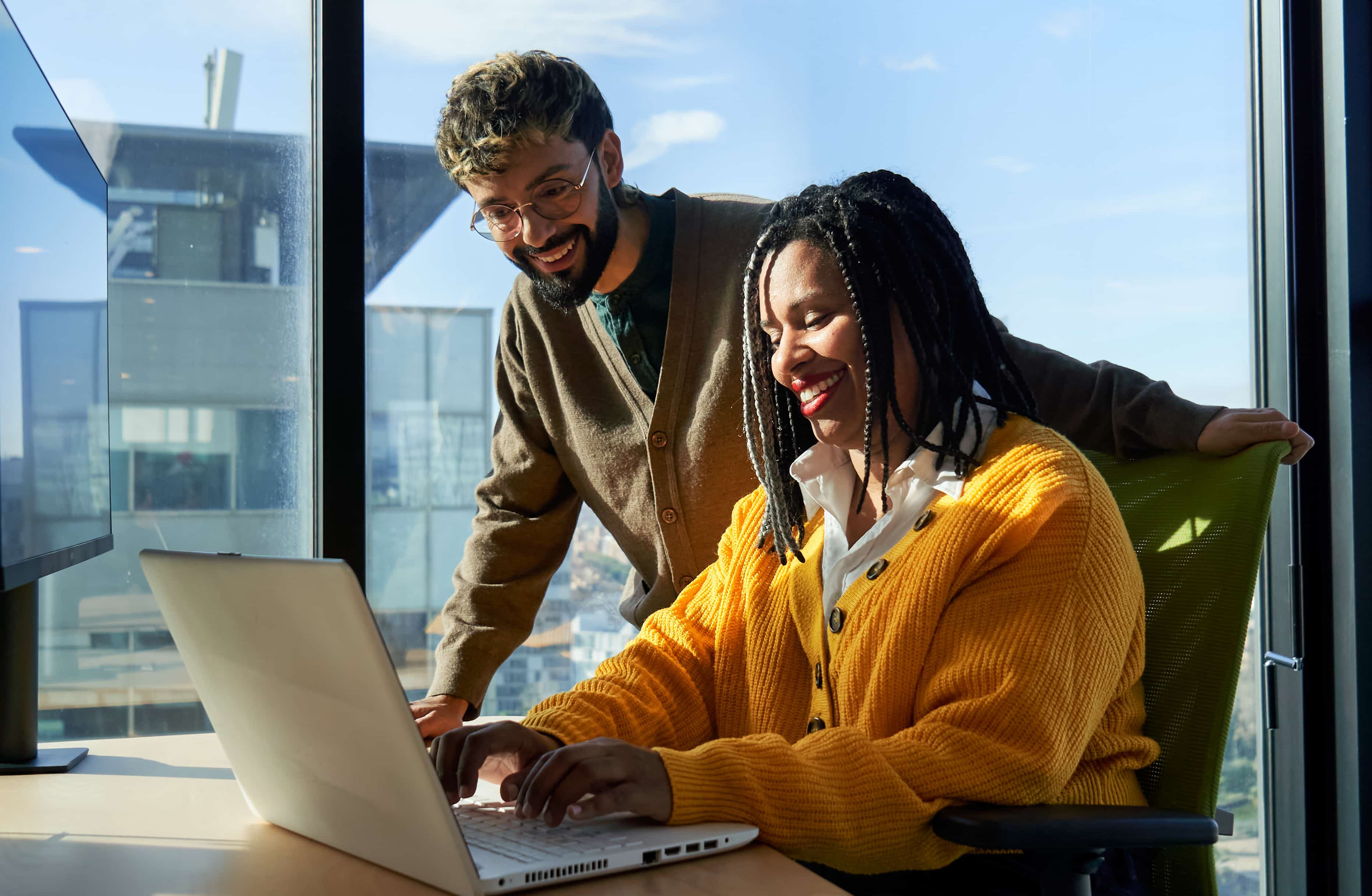 Business colleagues working together on laptop in office.