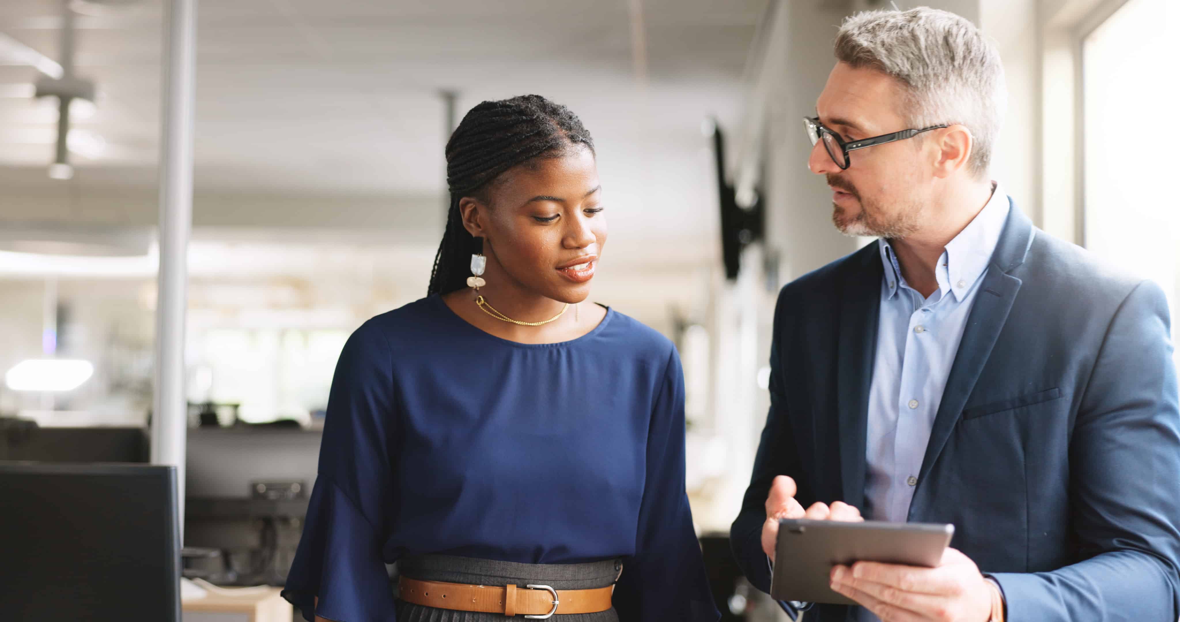 hr person providing leadership feedback on ipad to co-worker