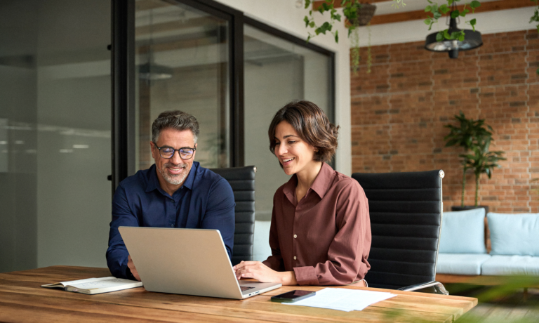Team Members Working Together On Laptop in Office