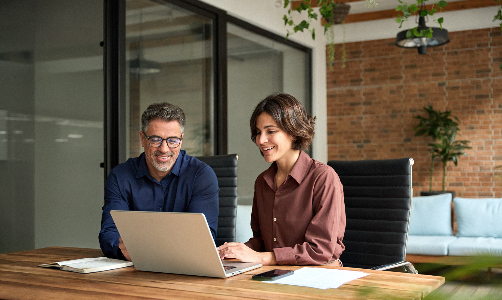 Team Members Working Together On Laptop in Office